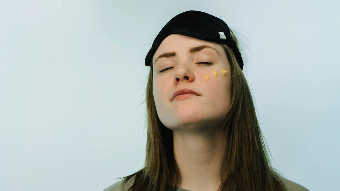 Vrouw met slaapmasker op haar voorhoofd ontspant met de ogen dicht tijdens haar avondroutine