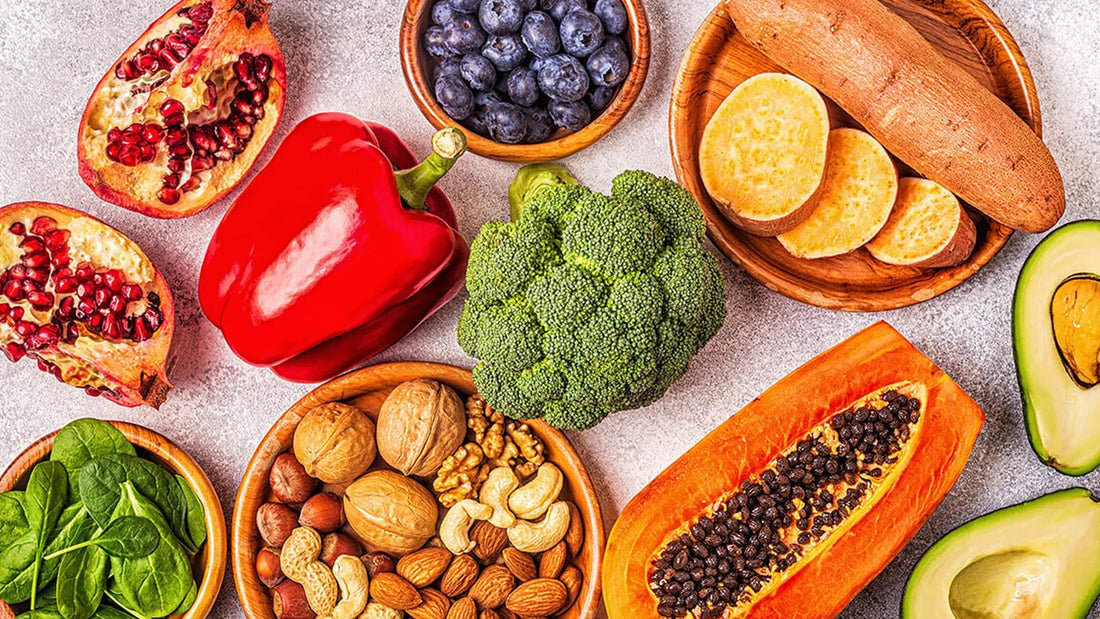 Groente, fruit, noten en avocado op tafel: eten dat vaak wordt genoemd bij een gezonde huid