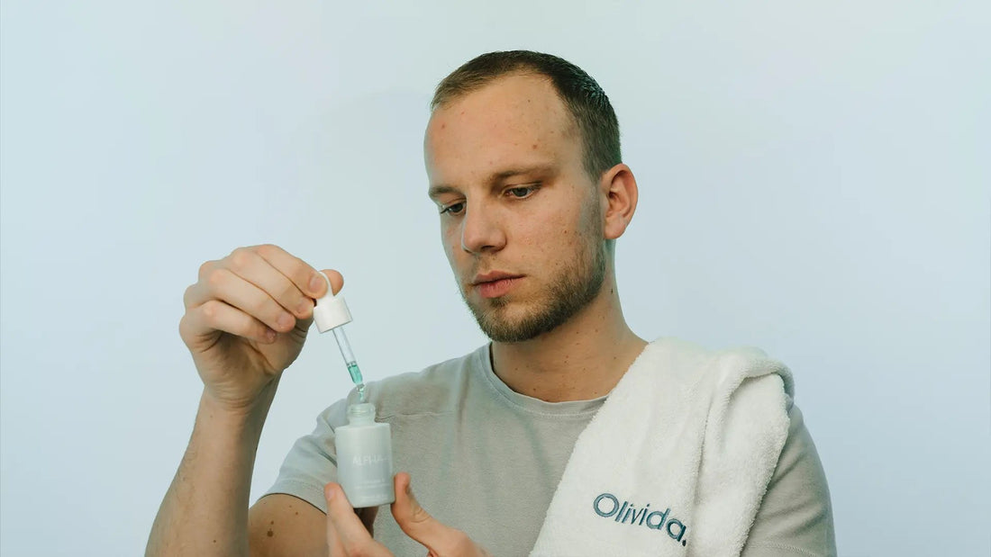 Man met Olivida-handdoek brengt een serum aan met een pipet
